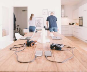 Couple working together in a modern kitchen, with devices on the table, discussing pre-marriage counseling near me.