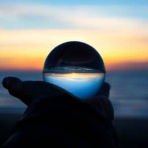 A hand holding a crystal ball reflecting a beautiful sunset, evoking clarity and vision, ideal for those seeking premarital counseling near me.