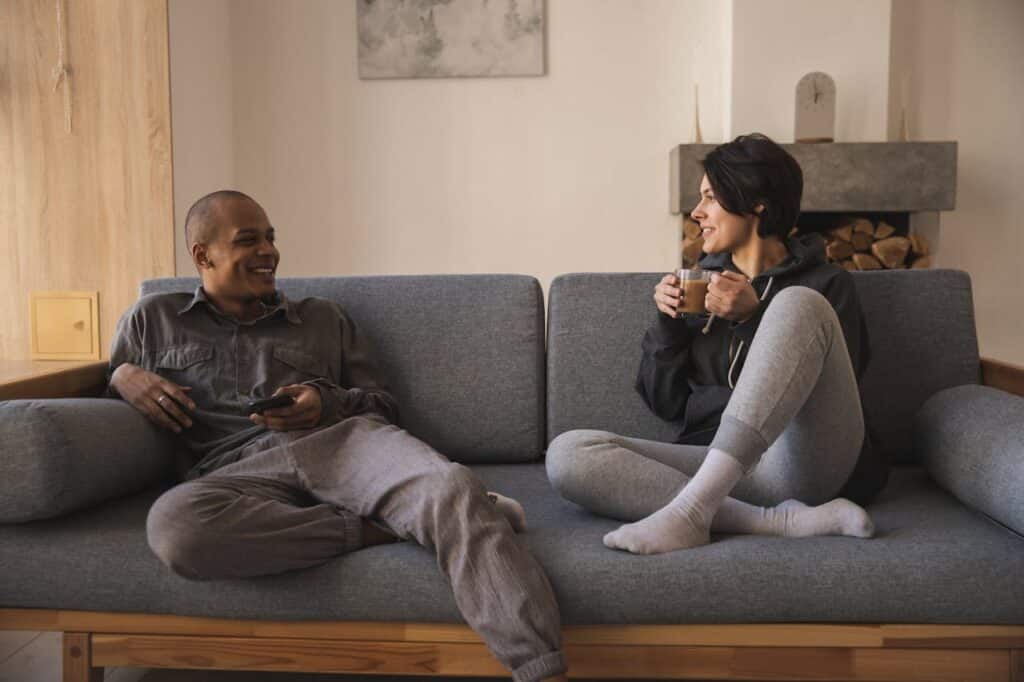 Couple sitting on a sofa having a relaxed conversation at home