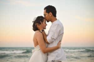 Couple embracing by the ocean, representing emotional connection and healing through couples counseling