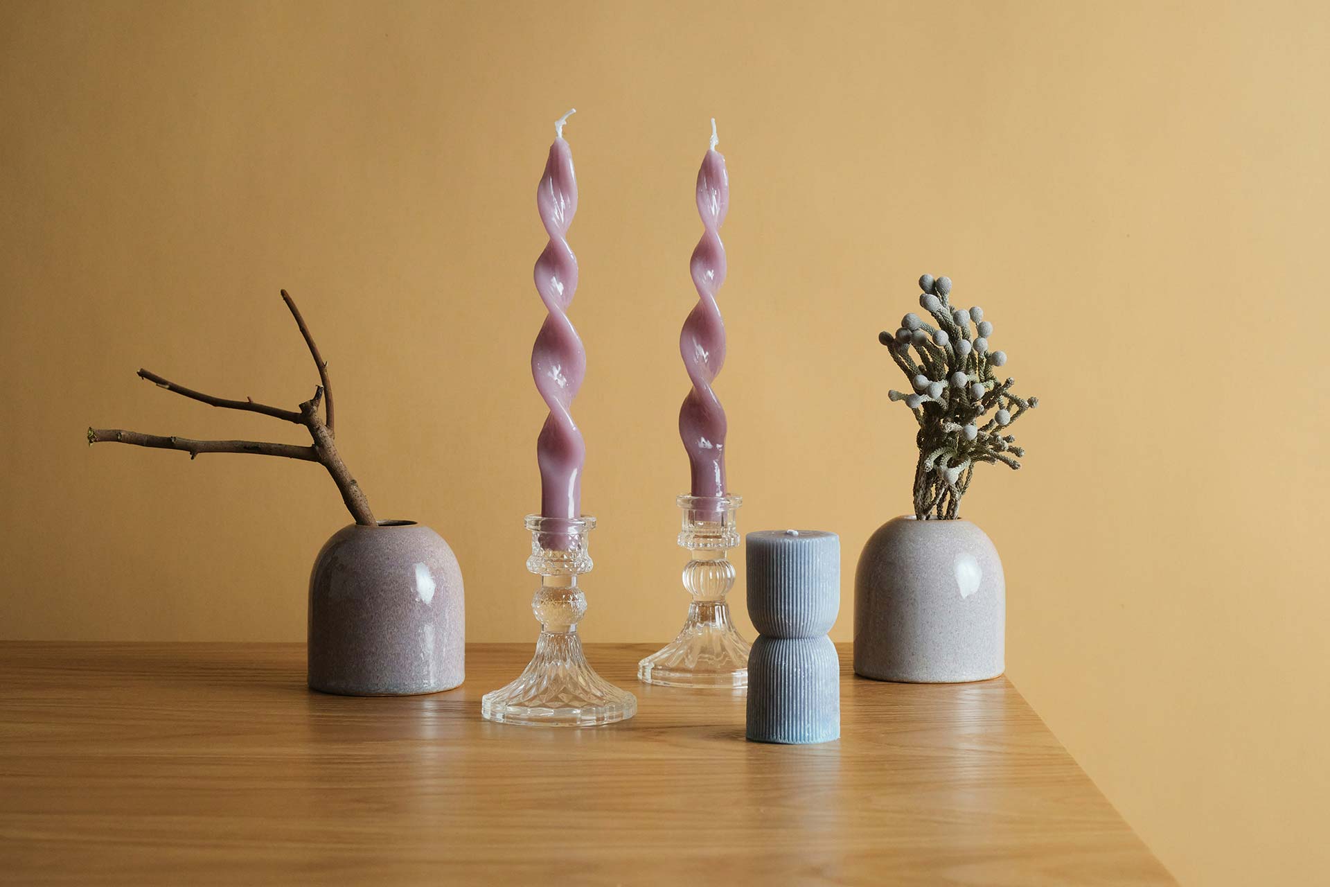 Wooden table topped with vases and candles
