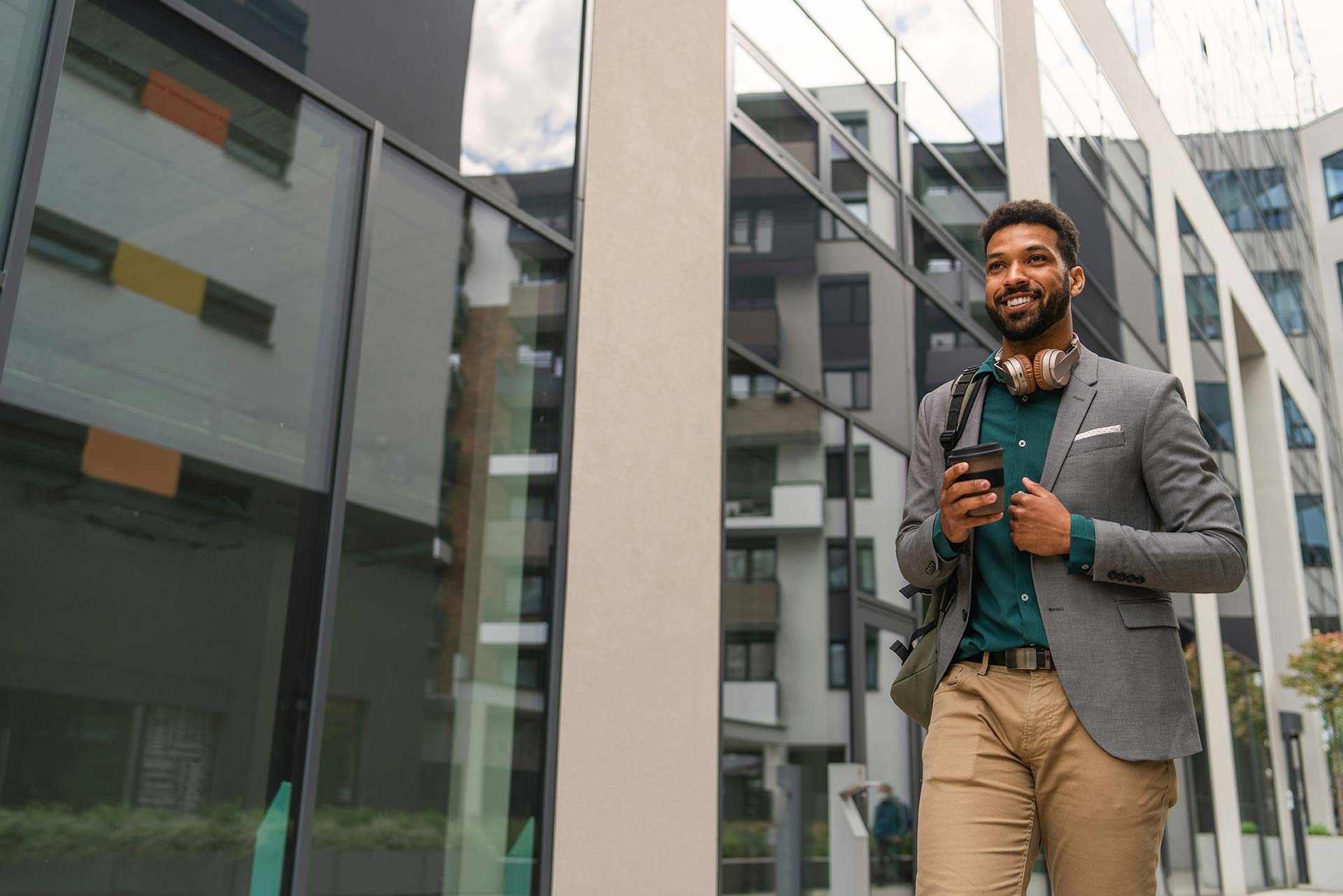 Front view of a student walking in front of a building.