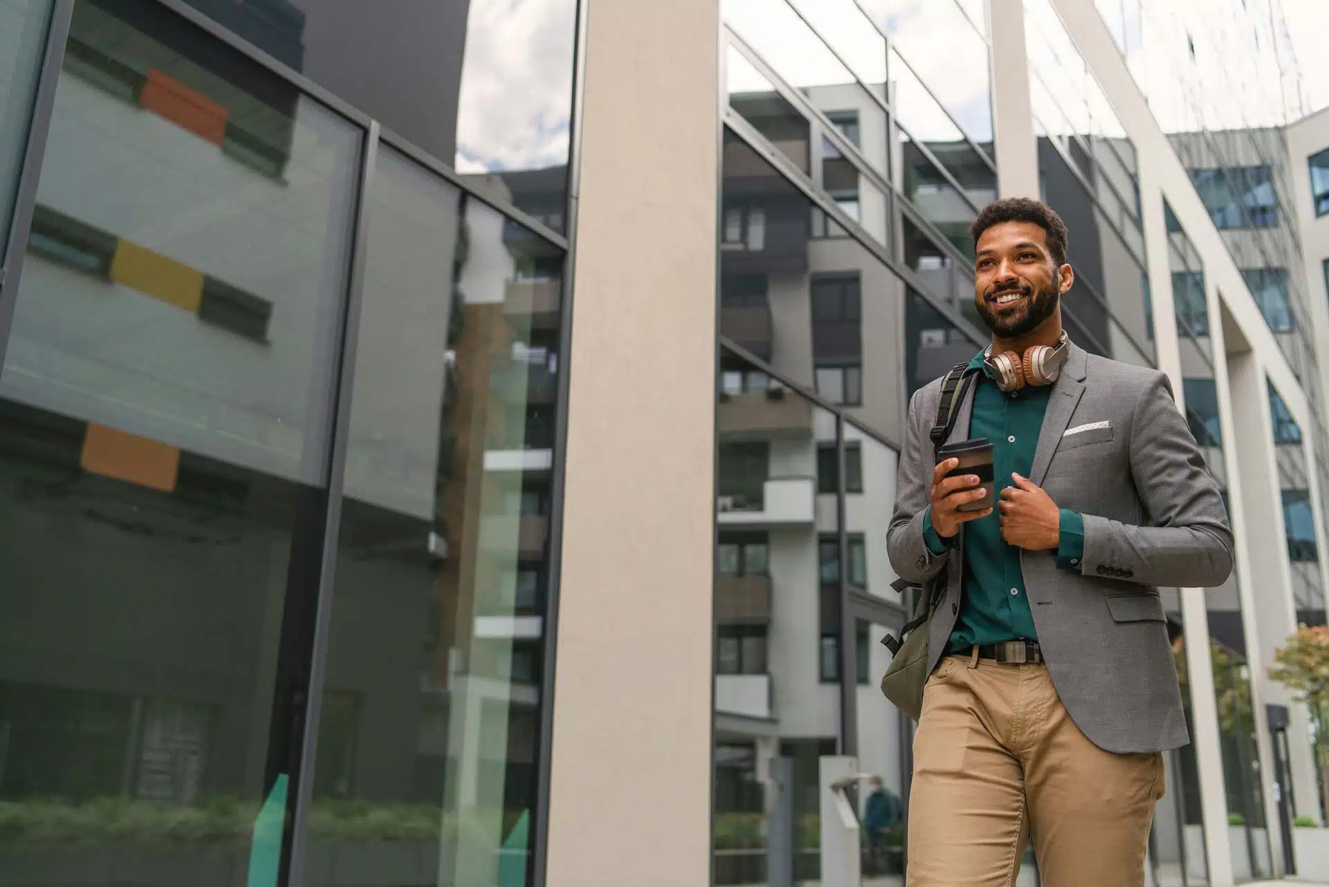 Front view of a student walking in front of a building.